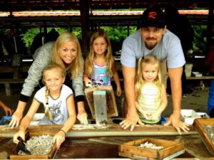 A family shows off their finds when flume mining for gemstones